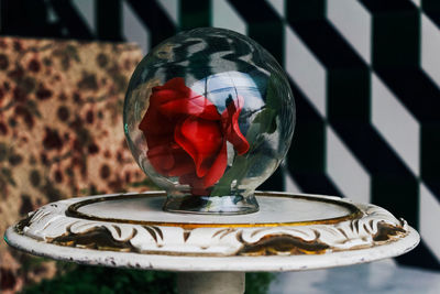 Close-up of red flowers in glass container on table