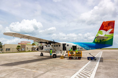 Airplane on airport runway against sky