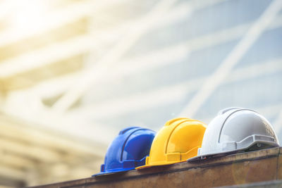 Close-up of hardhats on table against city