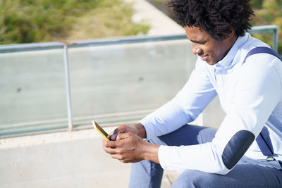 Side view of man using mobile phone