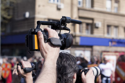 Cropped journalists photographing through camera