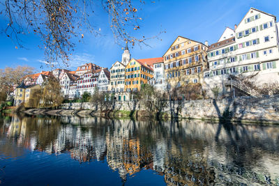 Reflection of trees and buildings on river