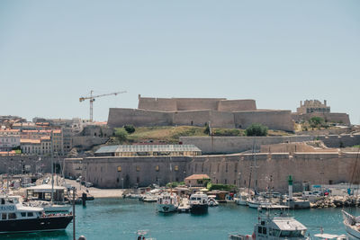 Boats in sea against clear sky