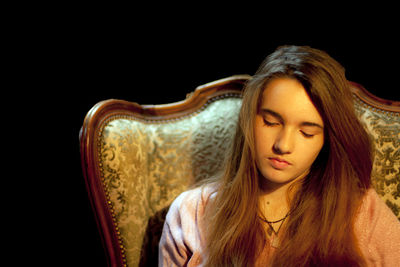 Young woman sitting on chair in darkroom