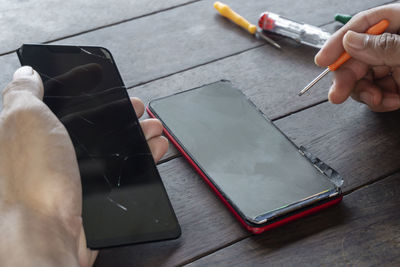 High angle view of person using mobile phone on table