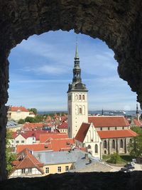 High angle view of bell tower in town against sky