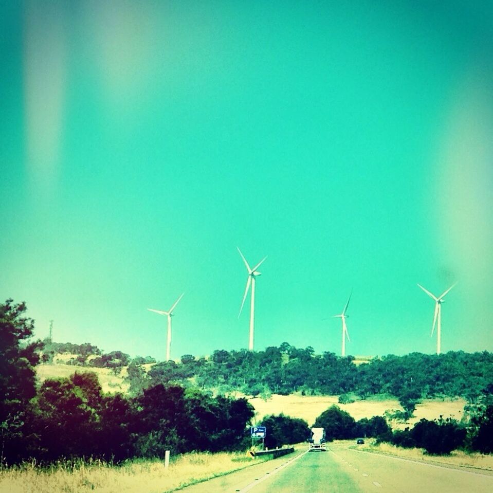 wind power, wind turbine, alternative energy, fuel and power generation, windmill, environmental conservation, renewable energy, landscape, field, technology, road, clear sky, copy space, rural scene, sky, transportation, nature, blue, outdoors, sustainable resources