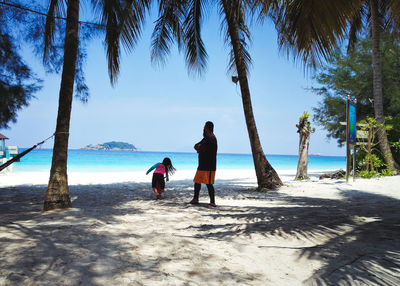 People at beach against sky