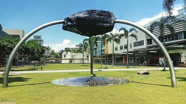 architecture, built structure, building exterior, tree, grass, clear sky, lawn, fountain, sculpture, park - man made space, blue, sky, city, sunlight, art, incidental people, statue, art and craft, arch, shadow