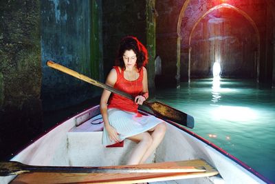 Full length of young woman sitting in water