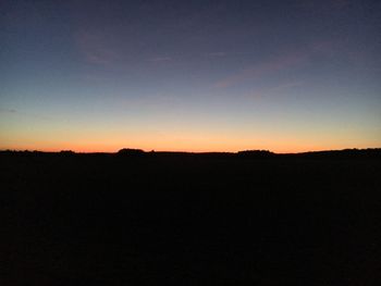 Silhouette landscape against clear sky during sunset