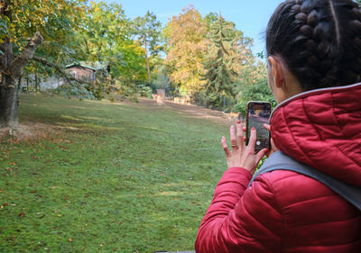 Rear view of woman sitting on grassy field