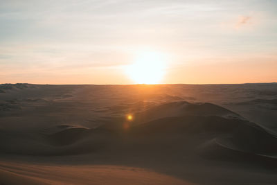 Scenic view of desert against sky during sunset