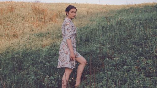 Portrait of beautiful young woman on field