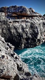 Scenic view of rocks in sea against sky