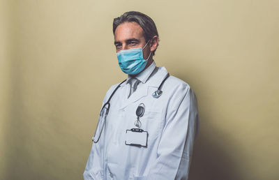 Doctor wearing mask against colored background