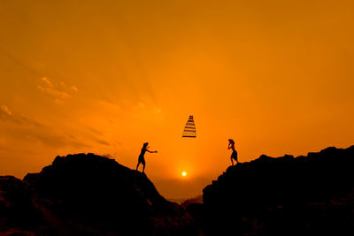 Silhouette people against sky during sunset