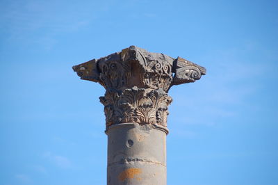 Low angle view of statue against blue sky