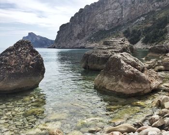 Rock formation in sea against sky