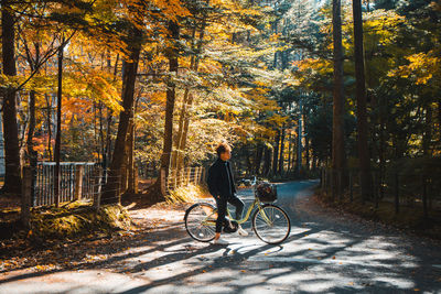 Man riding bicycle on street during autumn