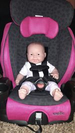 Portrait of cute baby boy sitting in toy car