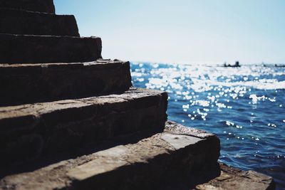 Rocks by sea against clear sky