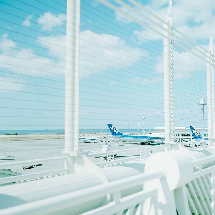 no people, day, air vehicle, airport, transportation, airplane, window, nature, travel, sunlight, white color, indoors, airport departure area, copy space, absence, blue, architecture, business, railing, aerospace industry, leaving, airport terminal