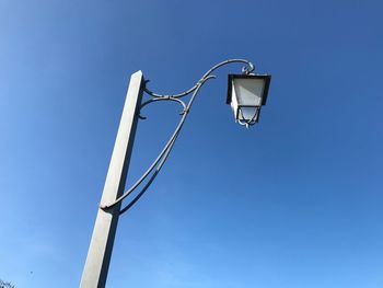 Low angle view of street light against blue sky