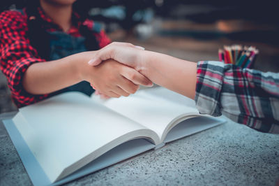 Friends shaking hands at table