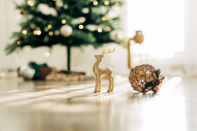 Golden deer and christmas ball on the background of the christmas tree, details of decorations. 