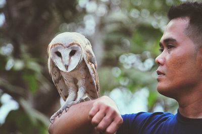 Close-up of boy holding bird