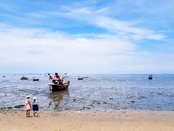 People on beach against sky