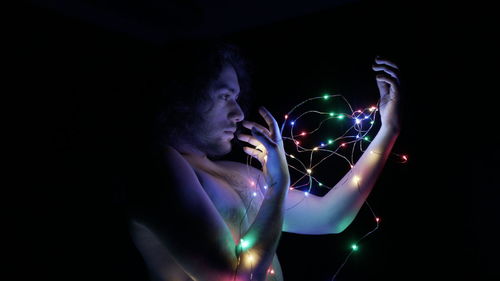 Close-up of hand holding illuminated string lights