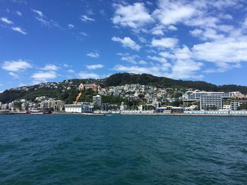 Scenic view of sea by houses against sky