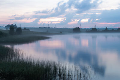 Scenic view of lake against sky at sunset