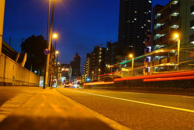 Light trails on road along buildings at night