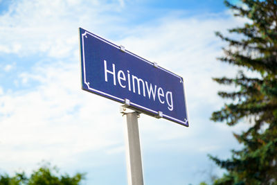 Low angle view of road sign against sky