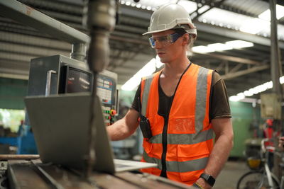 Rear view of man working in factory