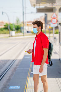 Young man standing on road in city