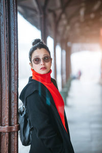 Woman wearing sunglasses standing at railroad station