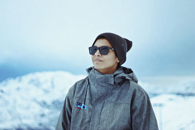 Portrait of man wearing sunglasses standing against sky during winter