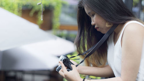 Midsection of woman holding camera