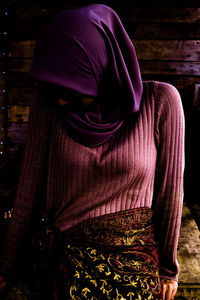 Rear view of woman wearing hat standing at home