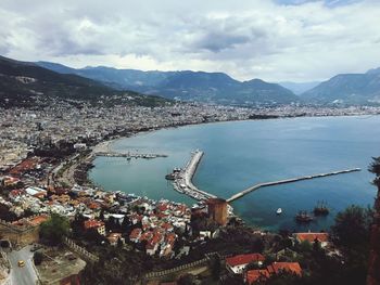 High angle view of townscape by sea against sky