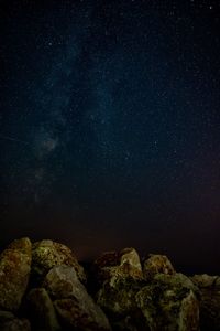 Low angle view of rocks against star field at night