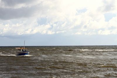 Boat sailing in sea against sky