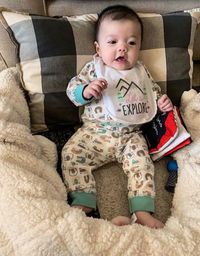 Cute baby lying down on bed at home