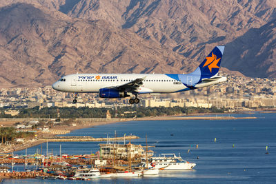 Airplane flying over sea and mountains