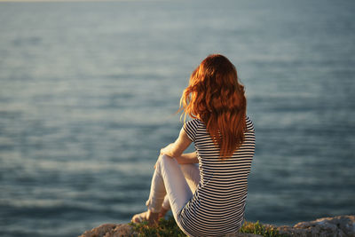 Rear view of woman standing against sea