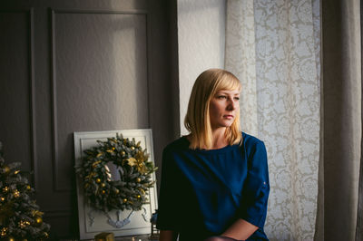 Thoughtful woman sitting at home